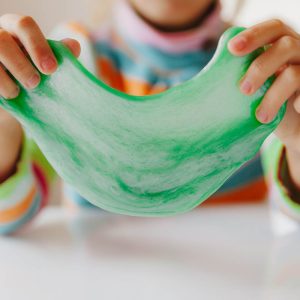 child stretching green slime