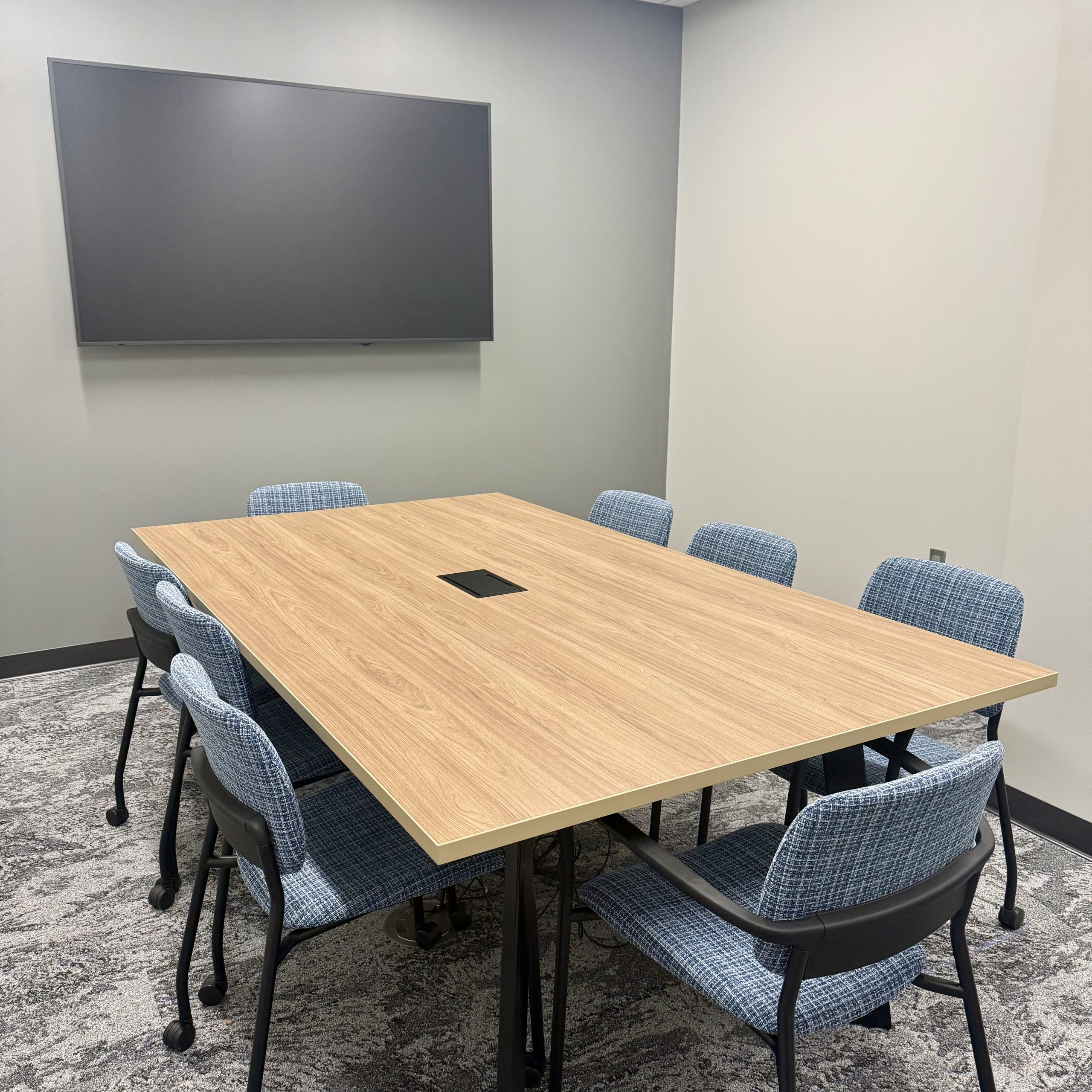 meeting room with eight chairs, board room table and tv screen